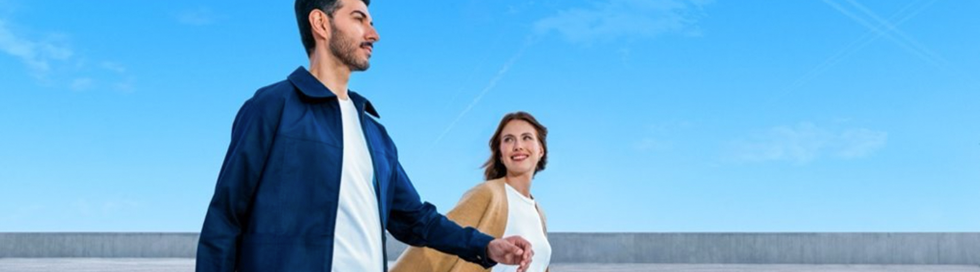 Image of a man and a woman walking with suitcases.
